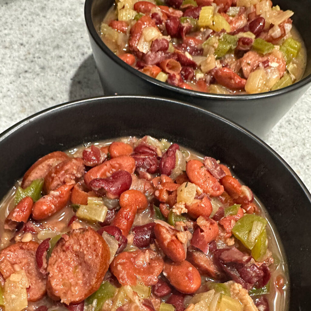 Image of two black bowls with red beans and rice in them.