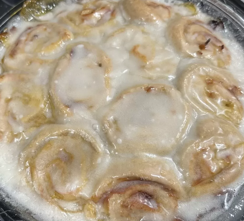 Image of sweet rolls in a pie dish covered with icing.